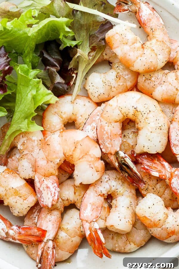 Plate of smoked shrimp with salad greens next to them.