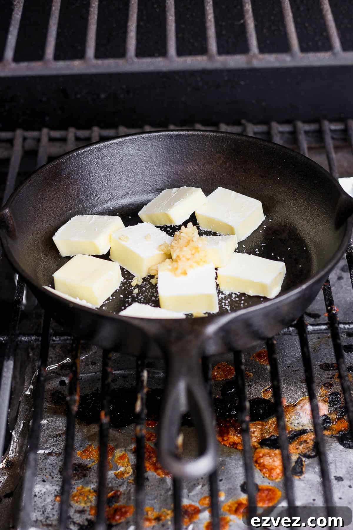 Cast iron skillet with smoked butter ingredients on the smoker.