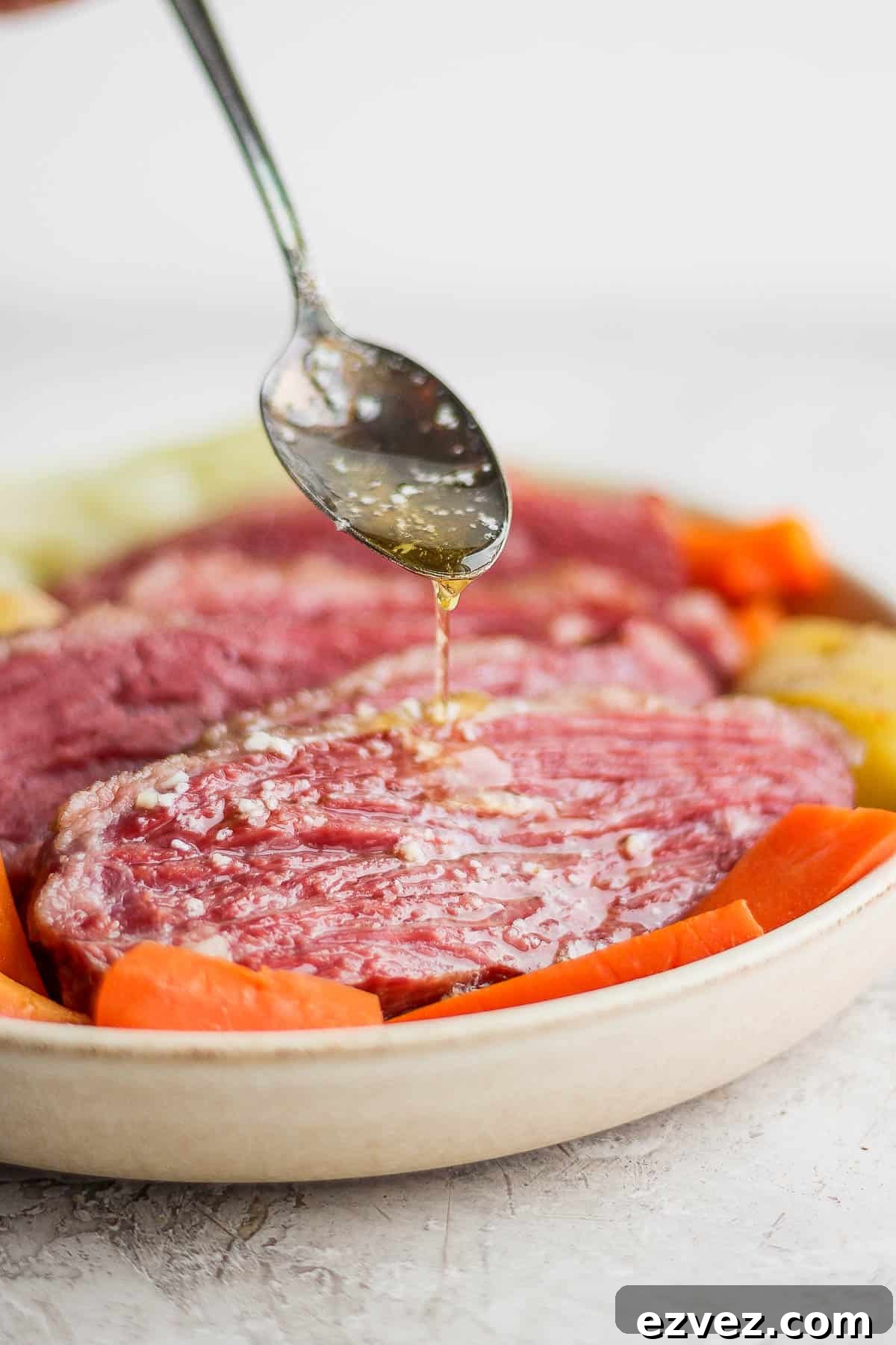 A little bit of smoked butter being drizzled on smoked corned beef.