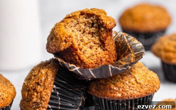 A stack of banana muffins with a bite missing from the top one.