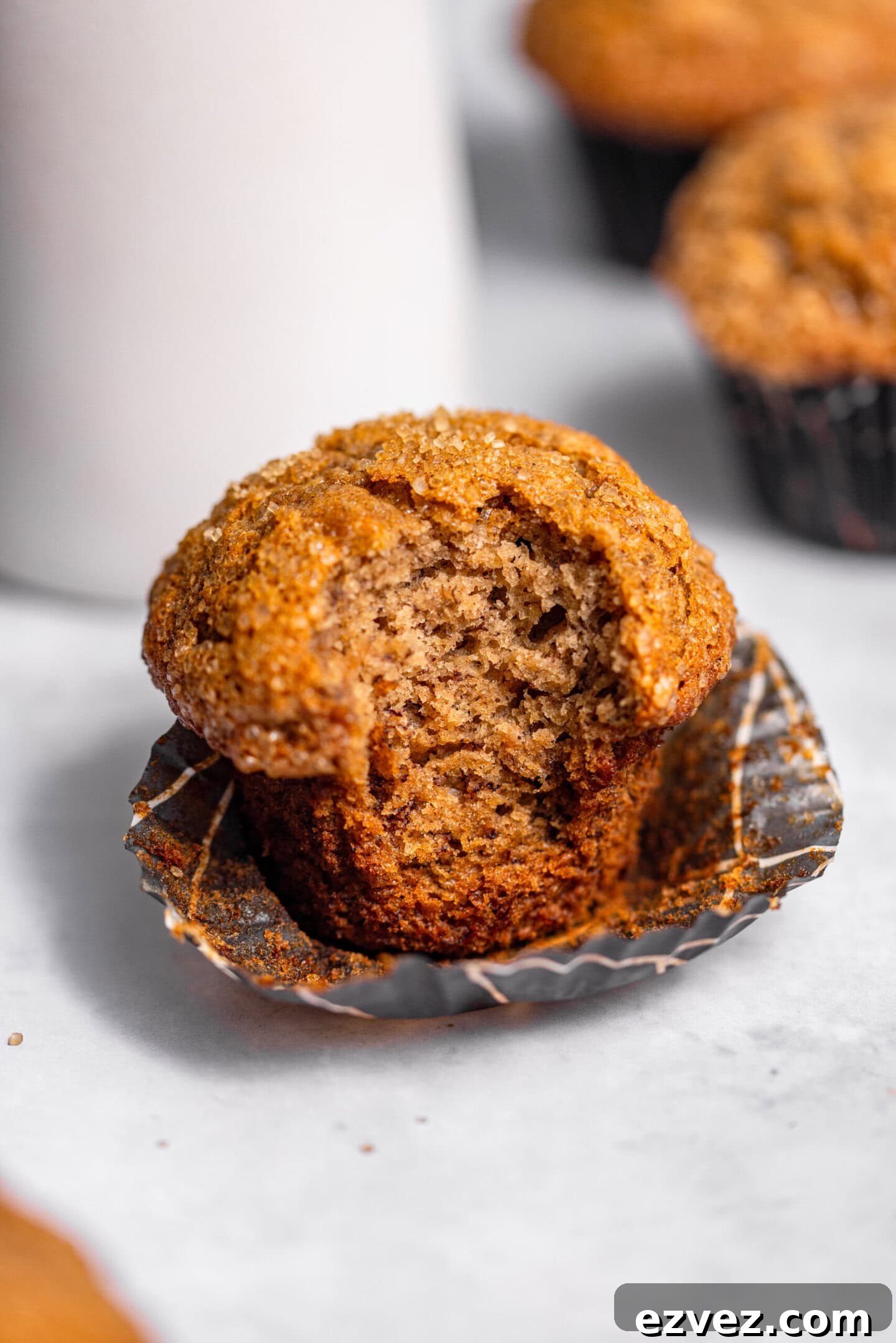 Close up of banana muffin with a bite missing showing moist and tender crumb interior