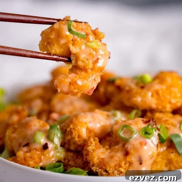 Crispy Beer Batter Recipe for Perfect Fried Fish and Vegetables 12 Bang Bang Shrimp being lifted with chopsticks.