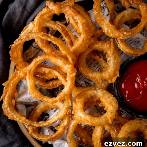 Crispy Beer Batter Recipe for Perfect Fried Fish and Vegetables 6 Onion rings on a plate with ketchup.