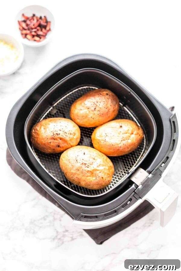 Crispy Air Fryer Baked Potatoes in 30 Minutes 3 Four baked potatoes in an Air Fryer.