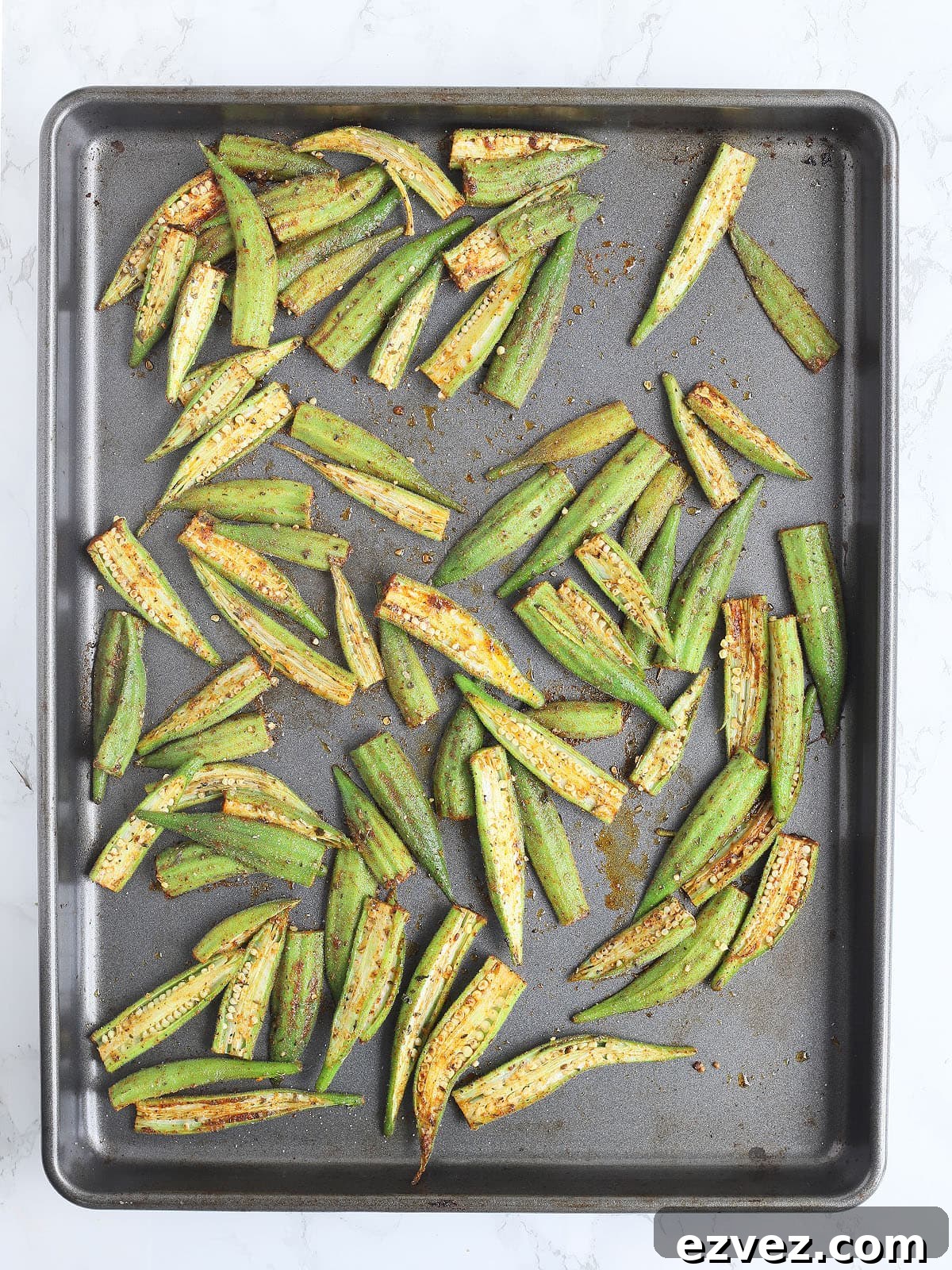 Sliced okra pods on a baking sheet.