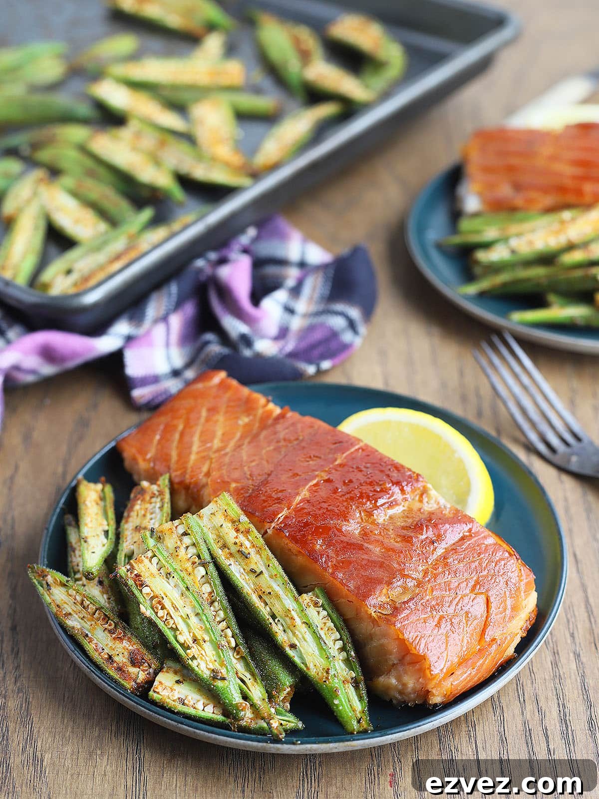 Roasted okra served alongside a salmon filet on a blue plate.