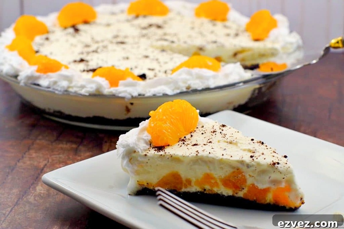 Piece of Orange Creamsicle pie (dairy-free) on white plate with whole pie in background