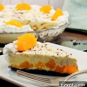 Piece of Orange Creamsicle pie (dairy-free) on white plate with whole pie in background