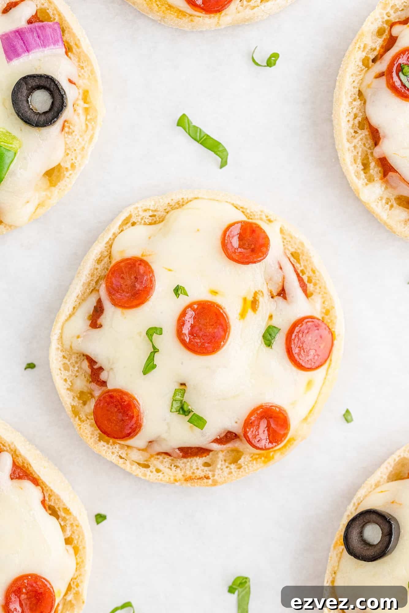 Quick English Muffin Pizzas for Fast Weeknight Dinner 2 Overhead view of a pepperoni english muffin pizza, others partially visible.