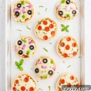 Quick English Muffin Pizzas for Fast Weeknight Dinner 8 Overhead view of english muffin pizzas on a parchment paper lined baking sheet.
