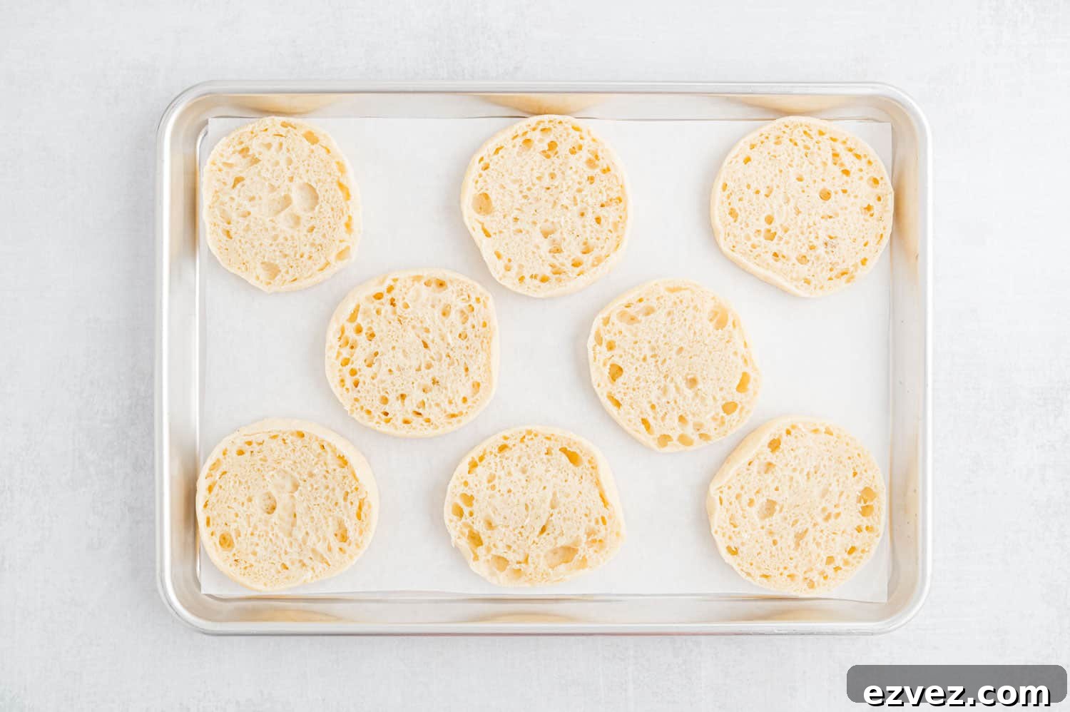 Quick English Muffin Pizzas for Fast Weeknight Dinner 4 English muffins cut in half, on a sheet pan.