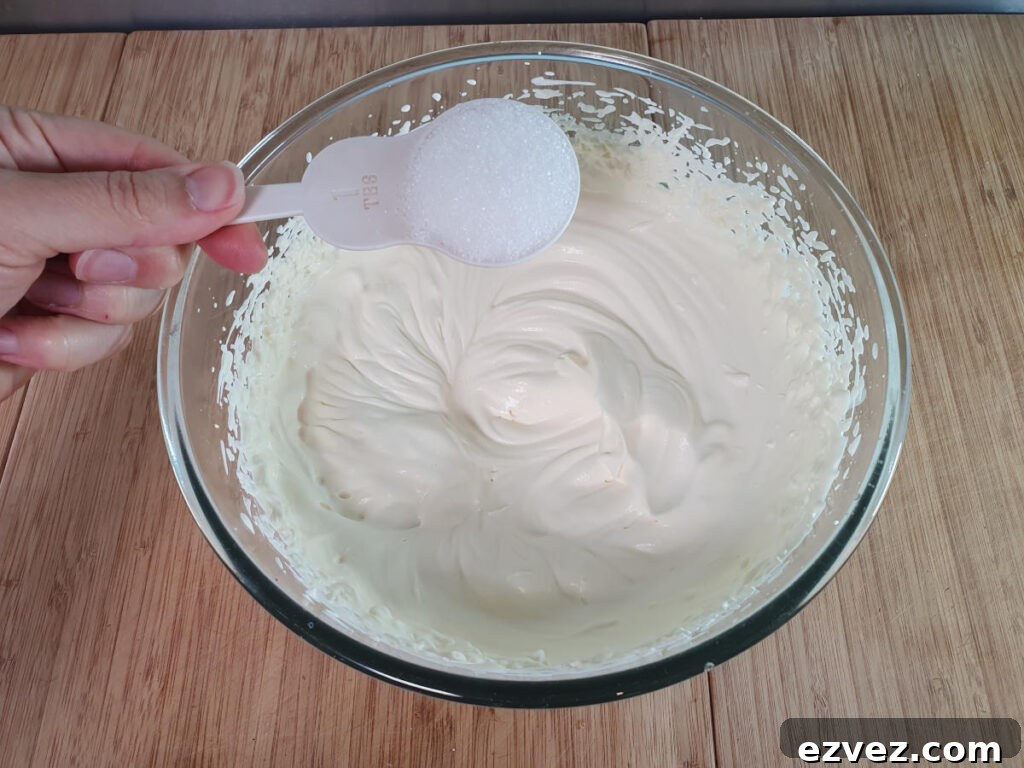 adding sugar to whipped cream.
