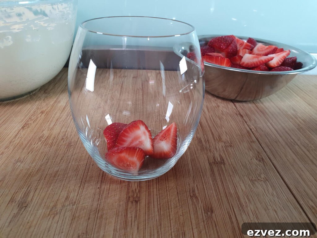 adding first layer strawberries to glass.
