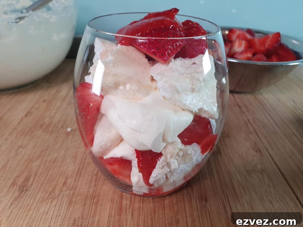 adding final layer strawberries and strawberry sauce.