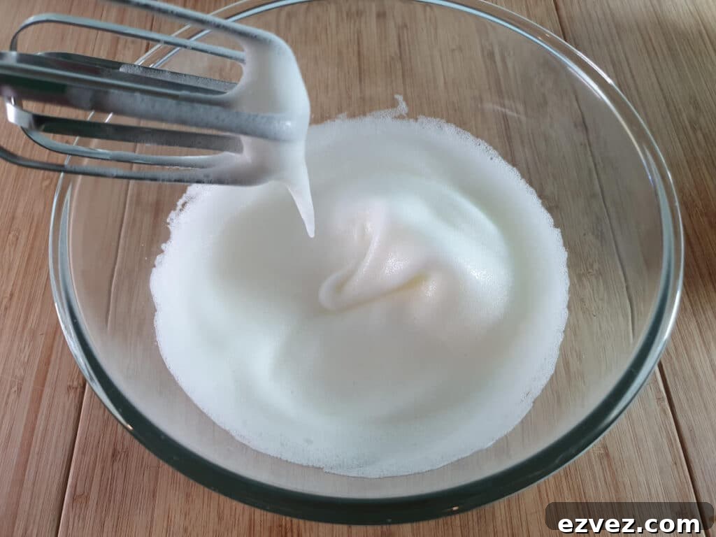 whipping egg whites to soft white peaks.