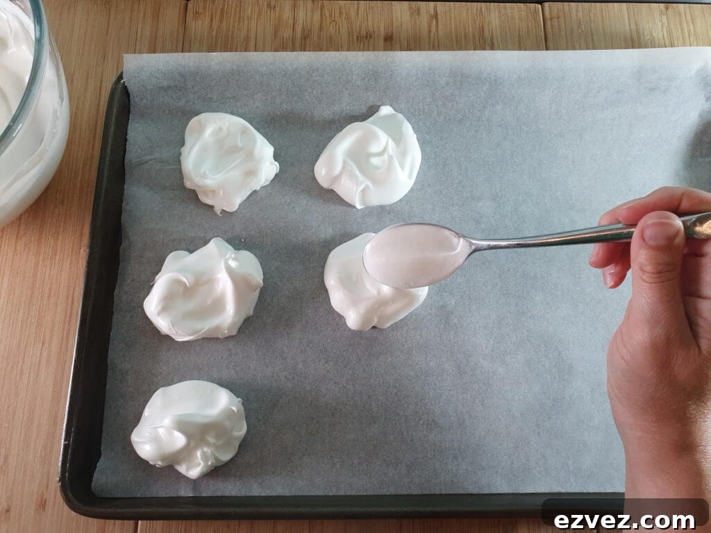 spooning meringue mix onto tray lined with baking paper.