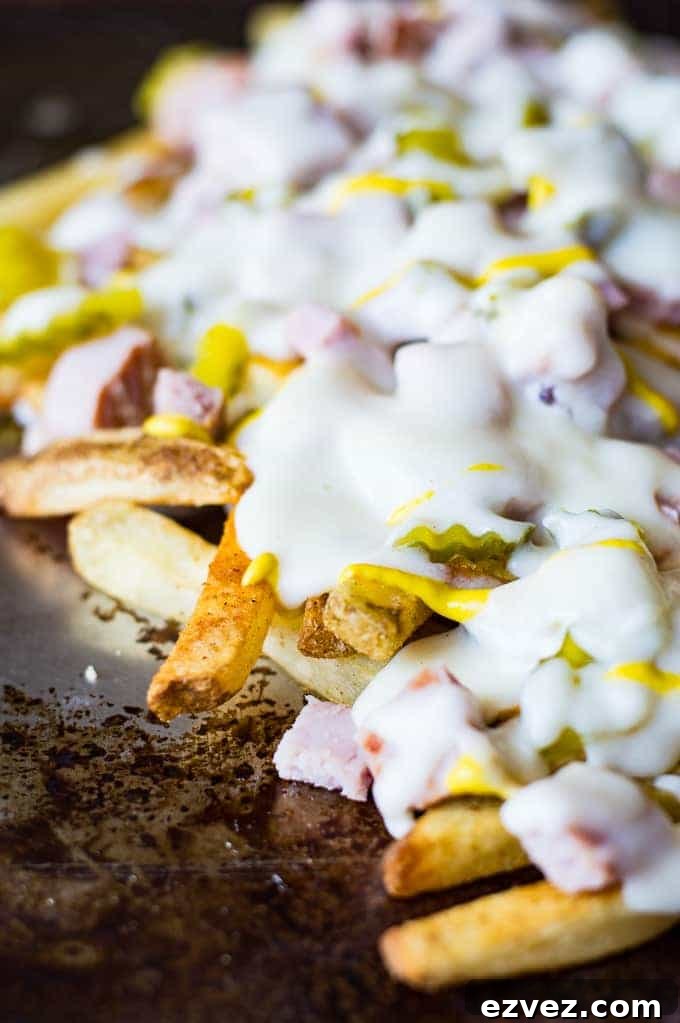 Crispy french fries loaded with all the flavors of a Cuban sandwich and topped with a creamy swiss cheese sauce! The ULTIMATE appetizer or snack recipe! A definite crowd pleaser!
