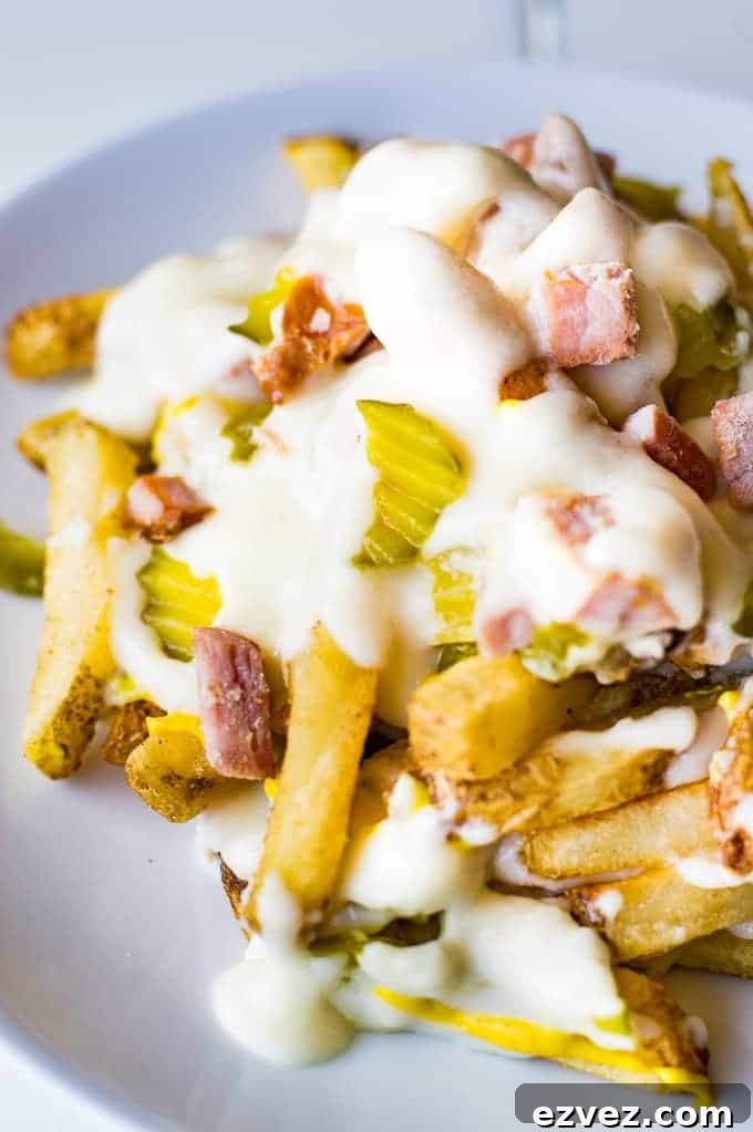Crispy french fries loaded with all the flavors of a Cuban sandwich and topped with a creamy swiss cheese sauce! The ULTIMATE appetizer or snack recipe! A definite crowd pleaser!