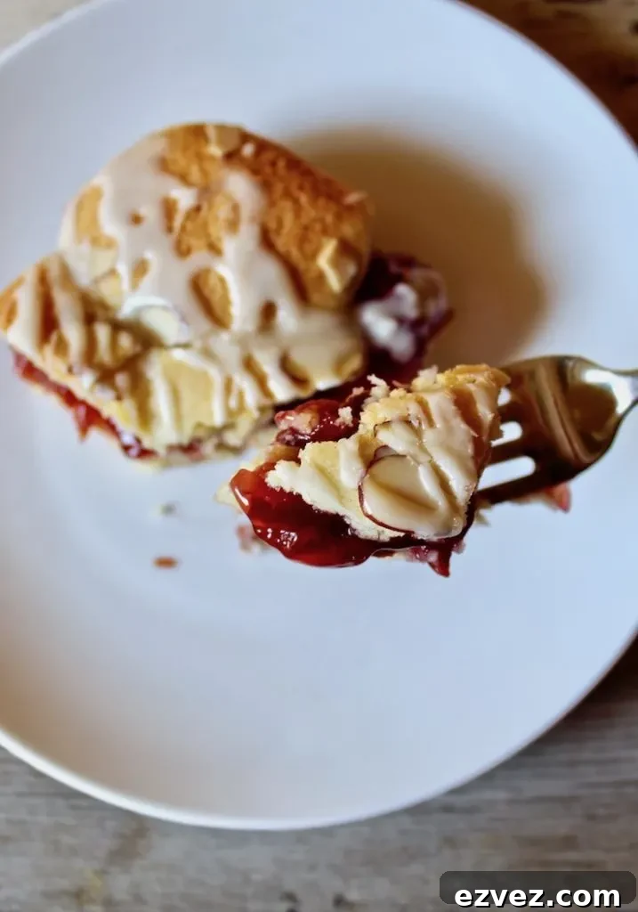 On plate with forkful of cherry pie bar.