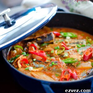 Kimchi Jjigae is made with canned mackerel pike fish in a blue pot.