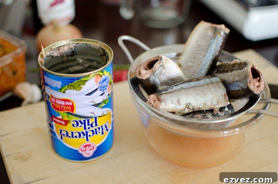 Canned mackerel pike is drained in a strainer.