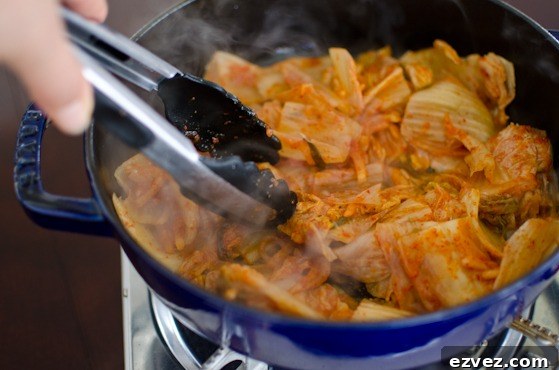 Kimchi is cooked in a little bit oil in a pot.