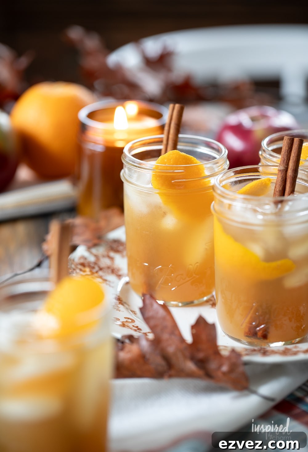fall cocktails served in jars with cinnamon stick and orange peel slice. 