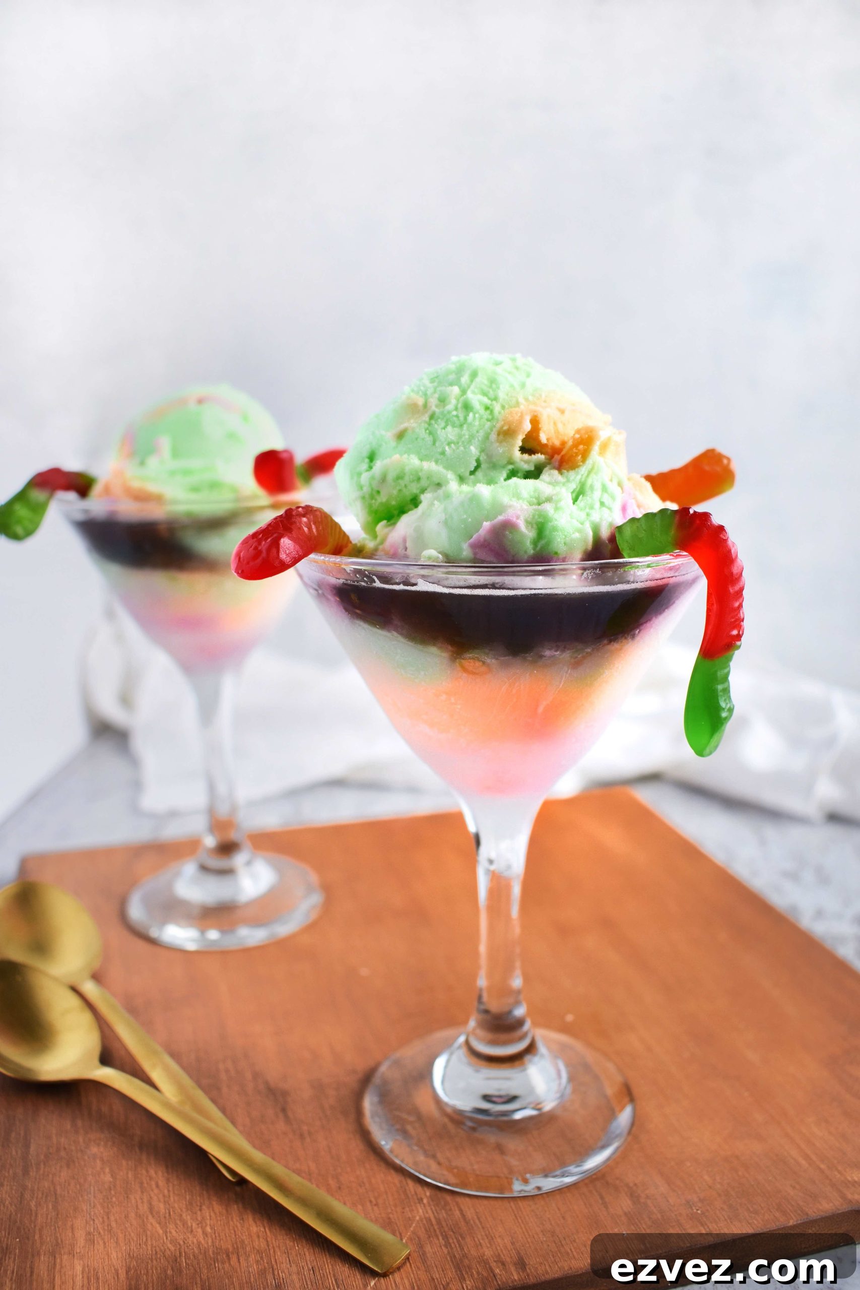 2 martini glasses with halloween floats and gummy worms hanging out
