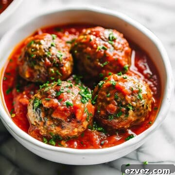 Aldi Weekly Budget Meal Plan: Feb 22–28 (7-Day Menu) 4 Homemade Italian style meatballs in a rustic tomato sauce in a white bowl.