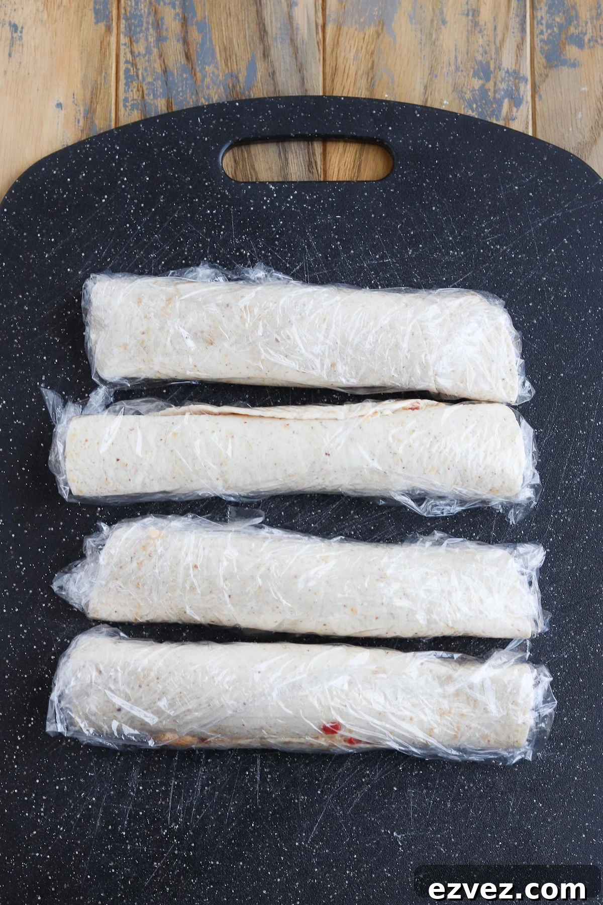 rolled up tortillas in plastic wrap