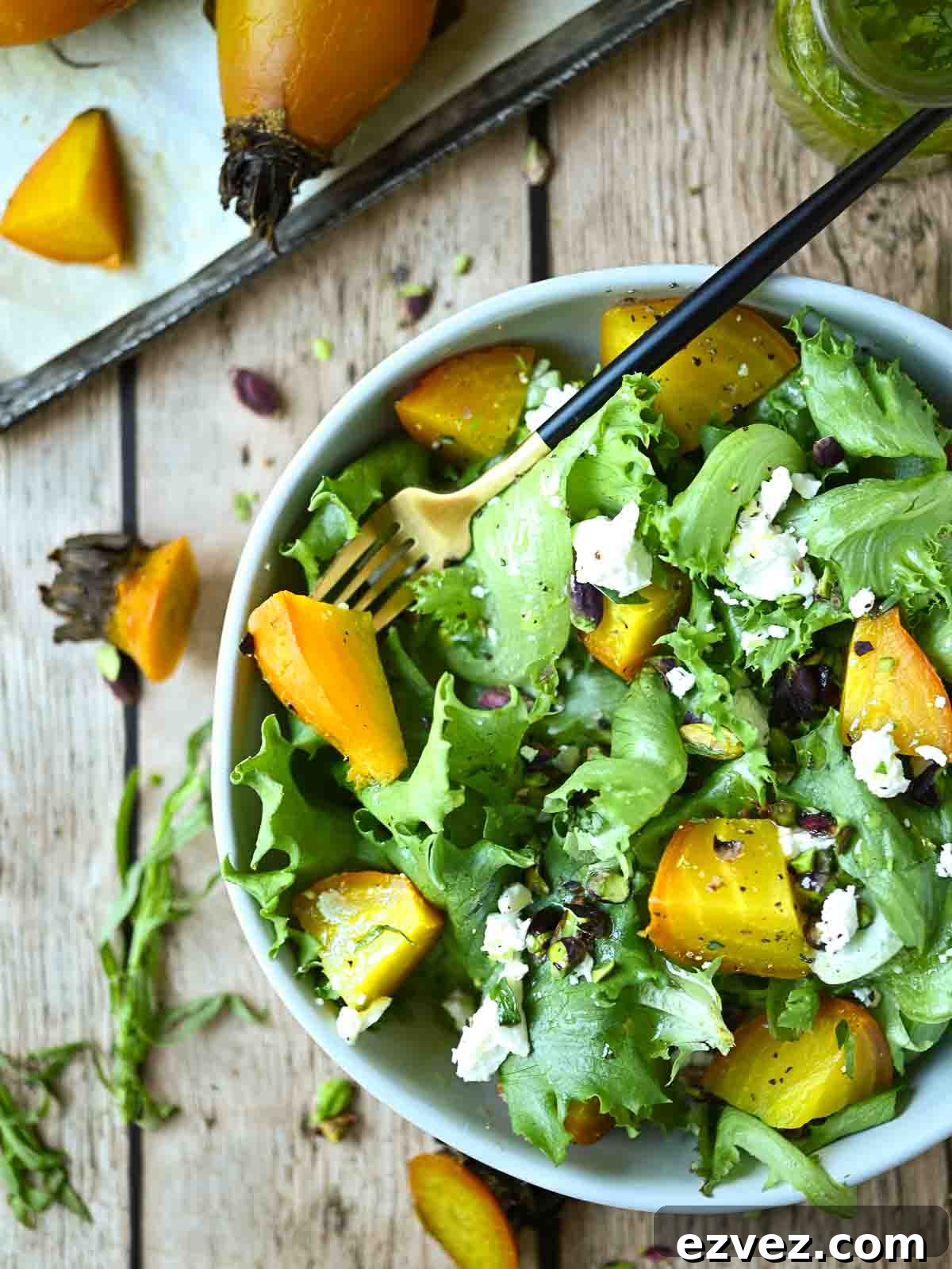 Overview of yellow beet salad with greens and cheese.