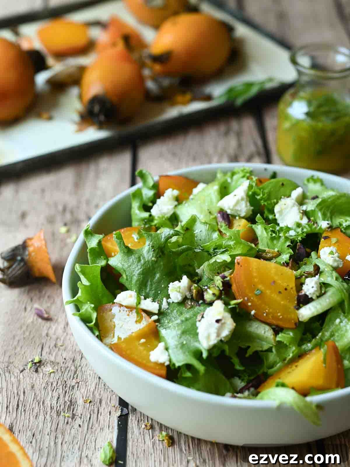 Eye-level view of golden beet salad in a white bowl on a wood surface.