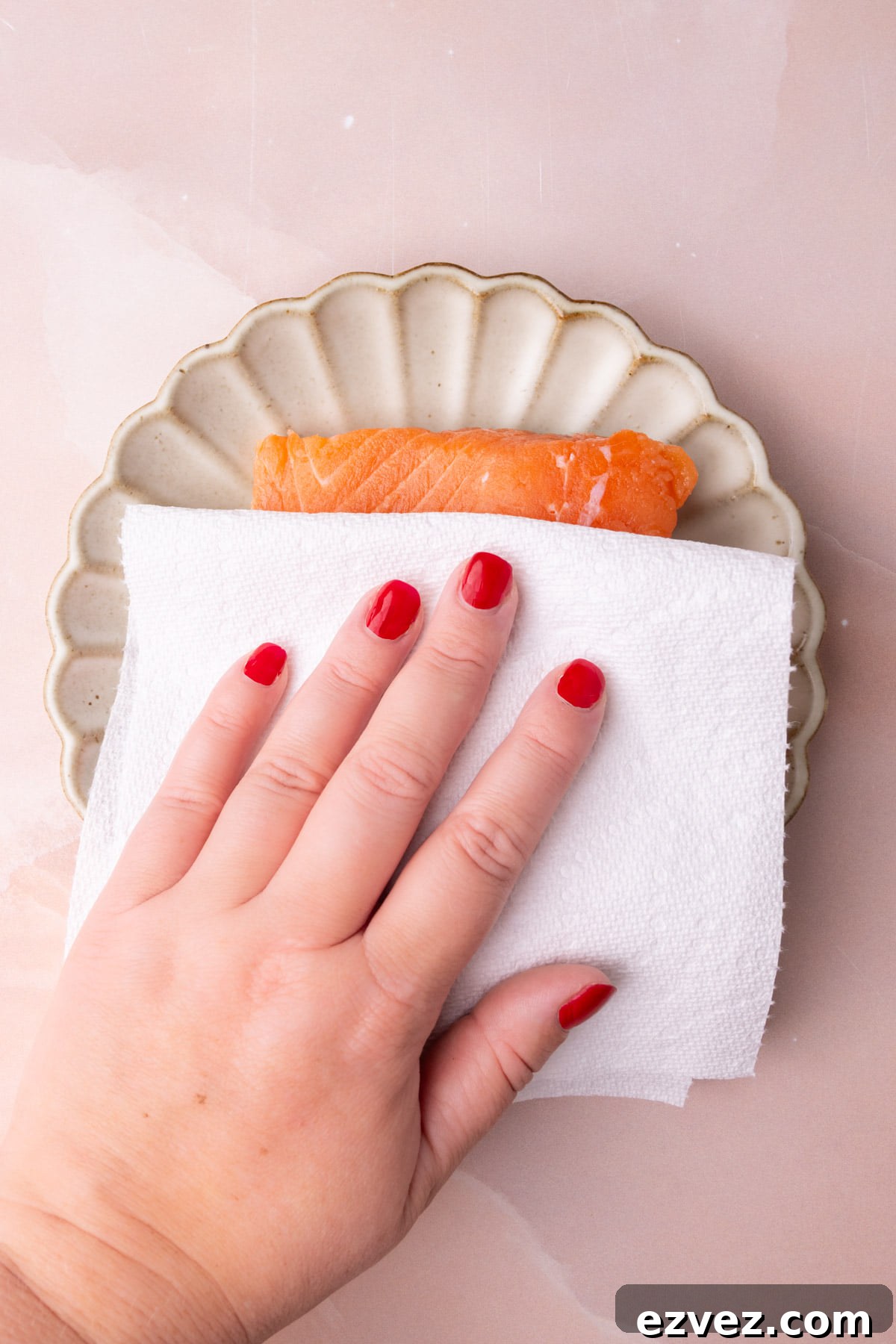 Blotting salmon dry with a paper towel for best texture after roasting. 