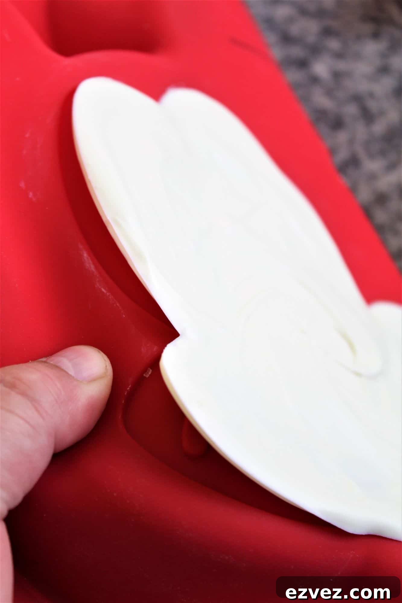 Decadent Gluten-Free Chocolate Cake Recipe for Perfect Texture 16 peeling the white chocolate mickey mouse face from red silicone cake mold.