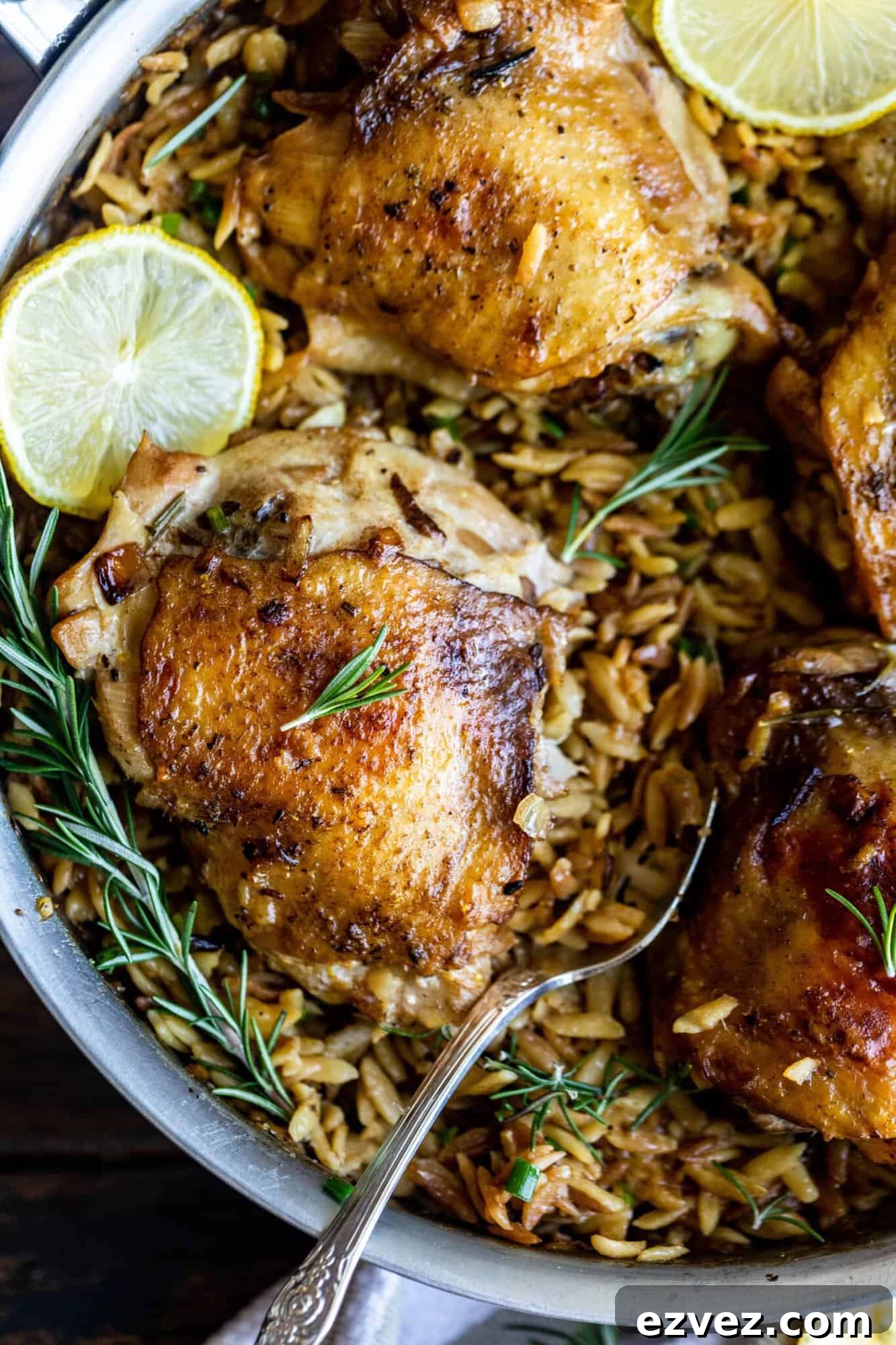 chicken and orzo in a pan with rosemary and lemon