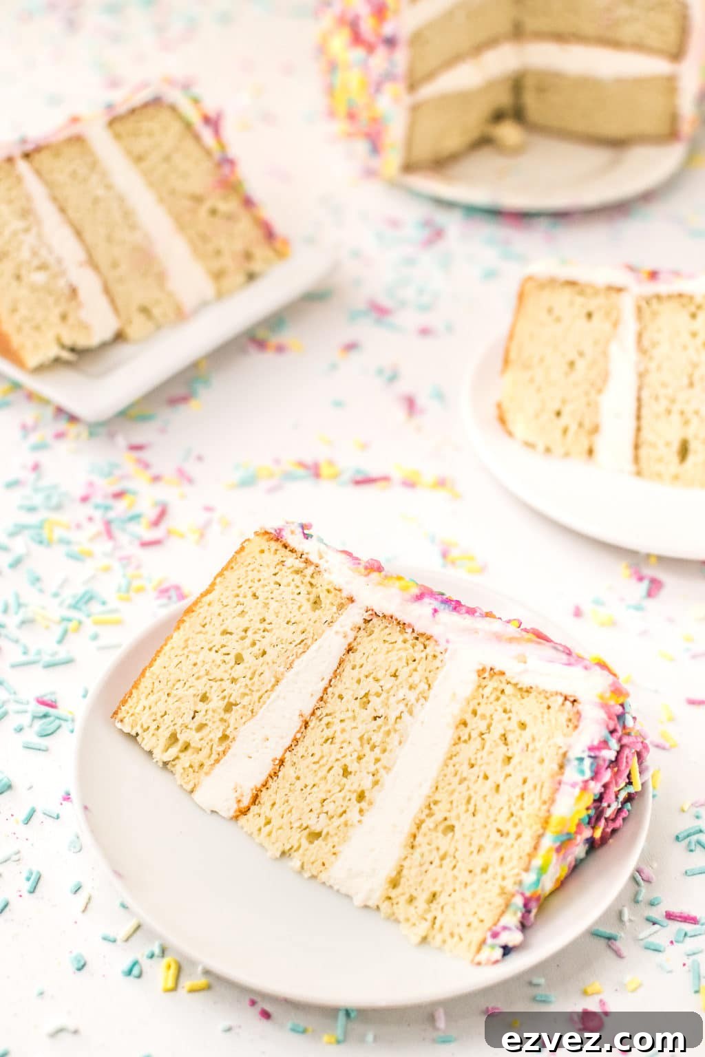 Slices of low carb birthday cake with white icing surrounded by sprinkles.