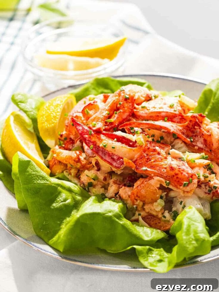Salad presented atop lettuce with lemon wedges.