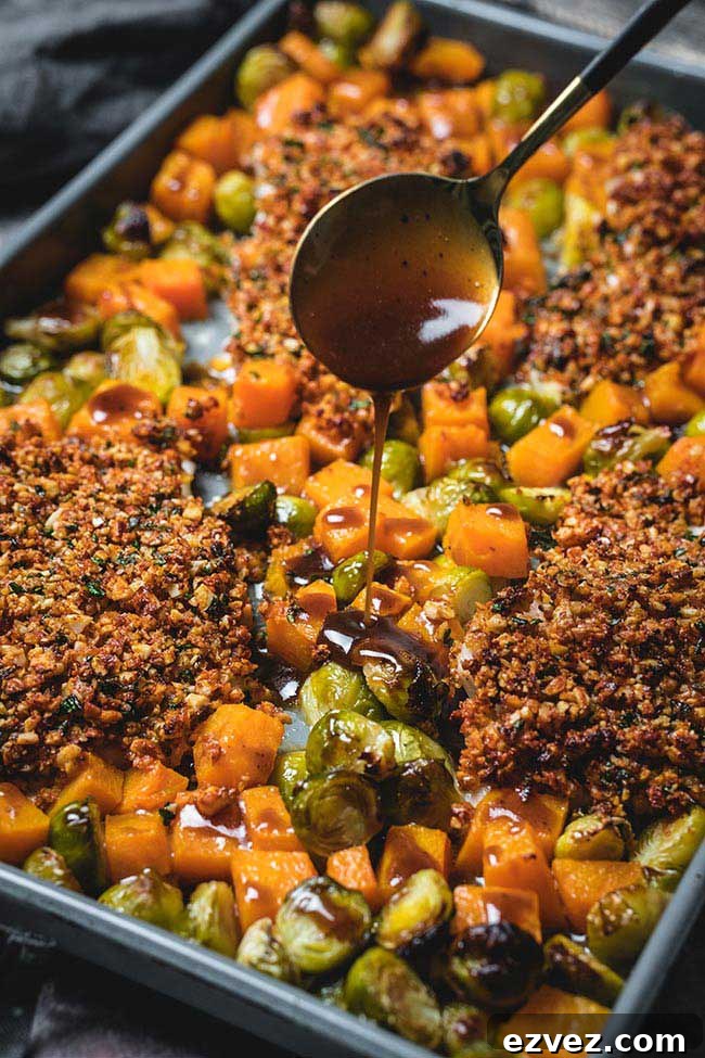 Finished recipe still on baking tray with a spoon drizzling sauce on top.