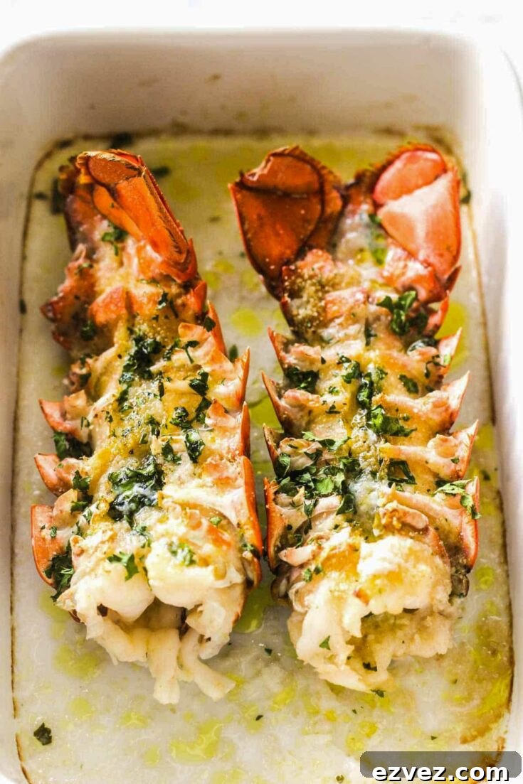 Two cooked lobster tails still in baking dish.