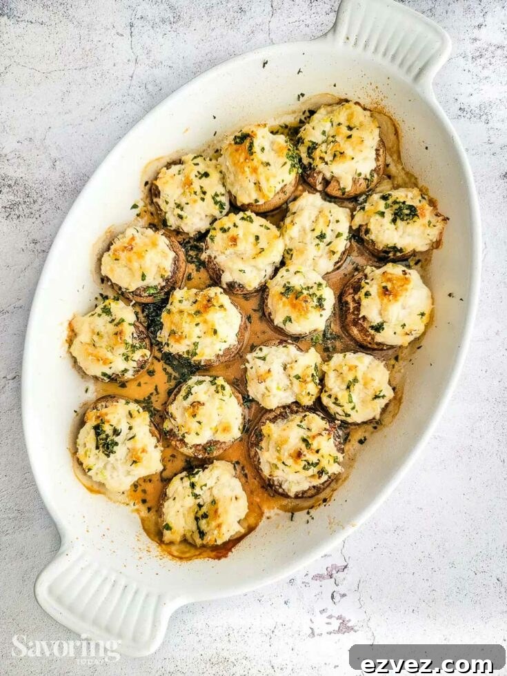 Overhead of stuffed mushrooms in oval baking dish.