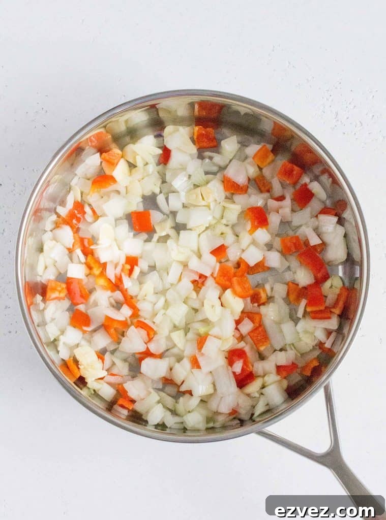 In a skillet on medium heat, add in the olive oil, onion, red bell peppers, garlic, and salt. Sauté for 3-5 minutes, until the onions have softened.