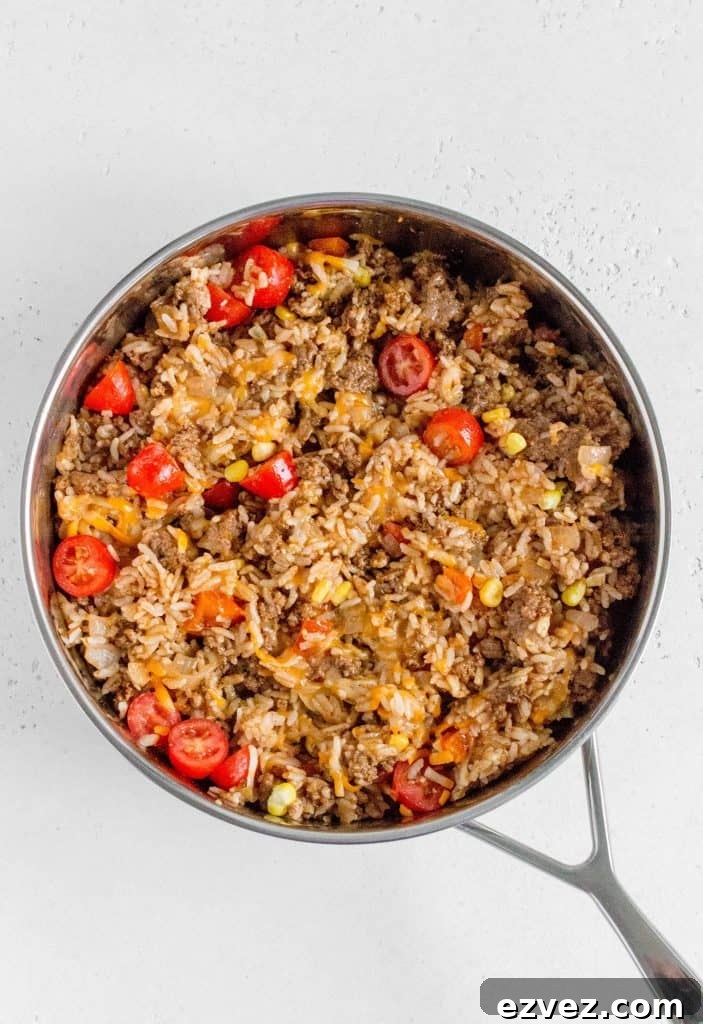 beef with rice corn tomato and cheese in the skillet
