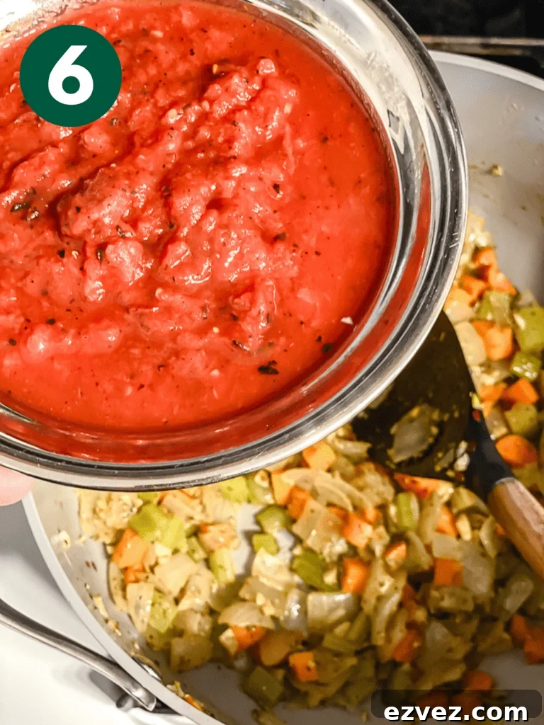 Hearty Spicy Lentil Soup Recipe with Warm Moroccan Flavors 9 process shot of adding tomatoes to pan