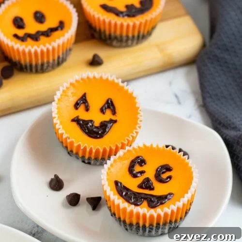 Jack-o'-Lantern Halloween Cheesecake Recipe for Party Treats 9 Mini Halloween Cheesecakes on a white plate with jack o lantern faces.