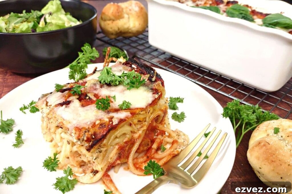 slice of baked spaghetti from the air fryer on a plate with a garlic knot