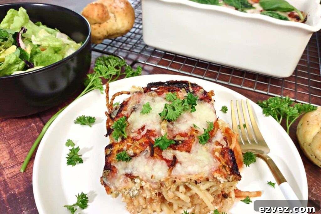 air fryer baked spaghetti on a plate with a side salad and garlic knots