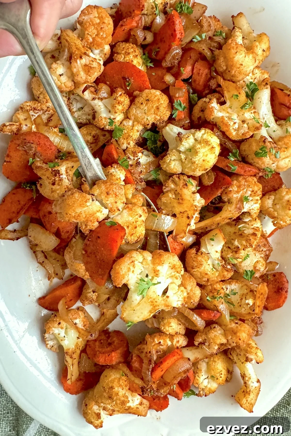 roasted cauliflower and carrots on white plate with spoon
