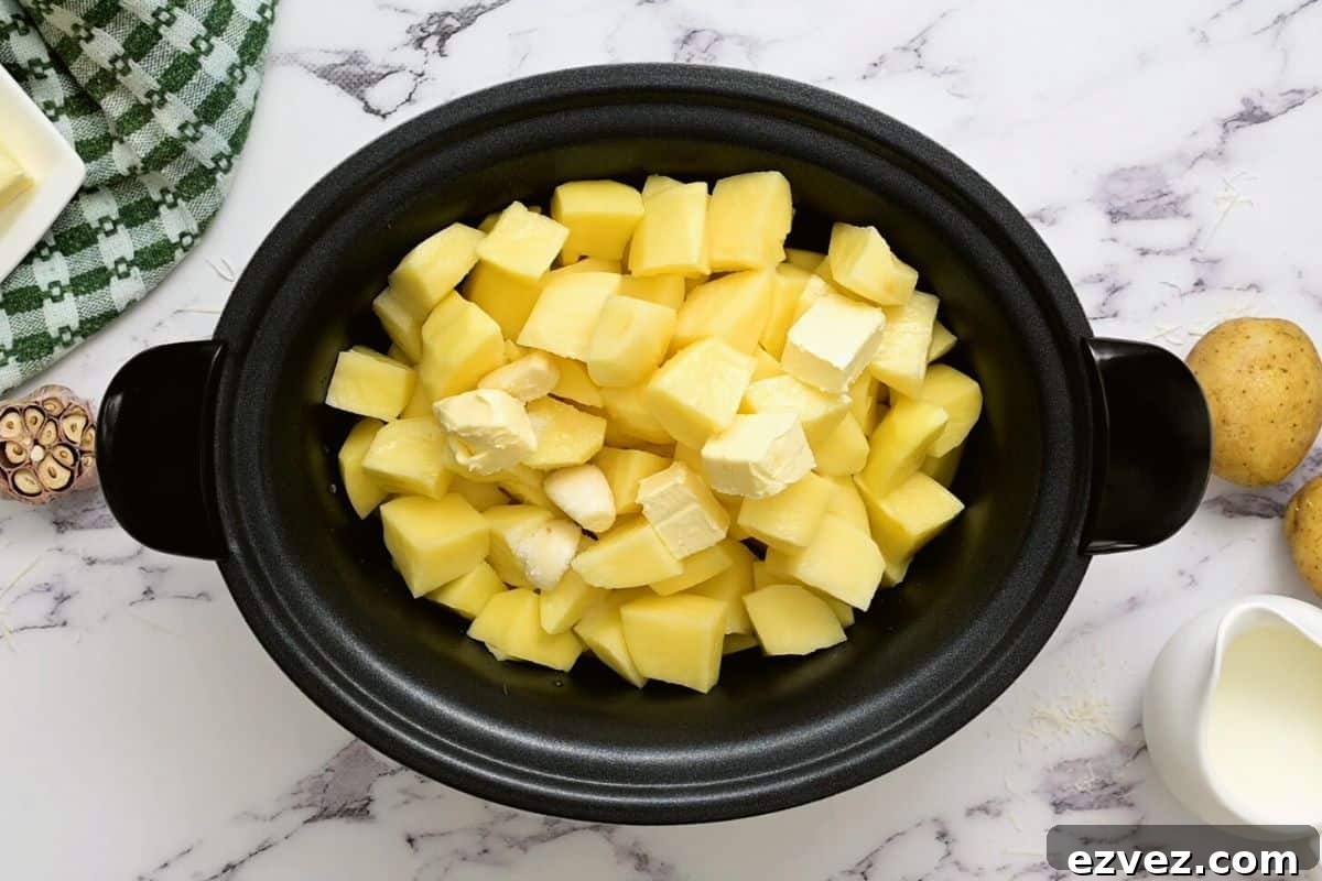 Cubed potatoes, butter, broth, and garlic in crockpot.