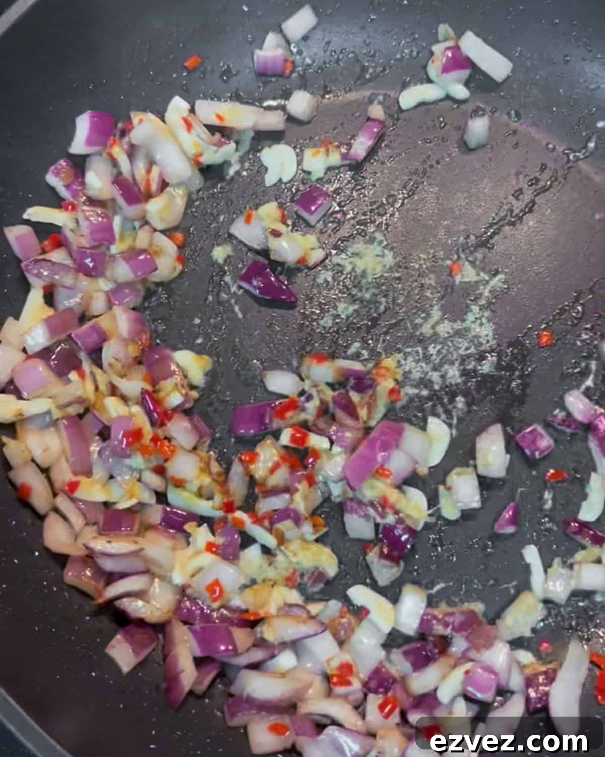 Photo of red onion, garlic, ginger and chilli stir-frying.
