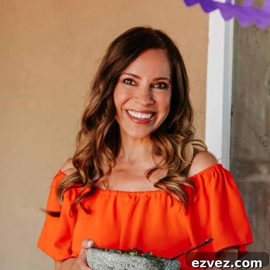Colorado-Style Green Chile Pork Roast Recipe 4 Yvette Marquez muy bueno Mexican food blogger in an orange dress holding a molcajete.